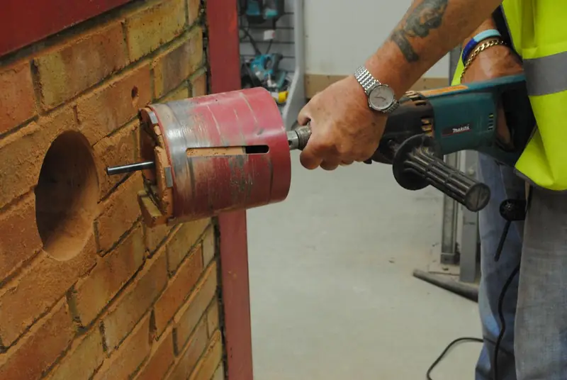 Diamond core bit drilling a horizontal hole through a masonry wall