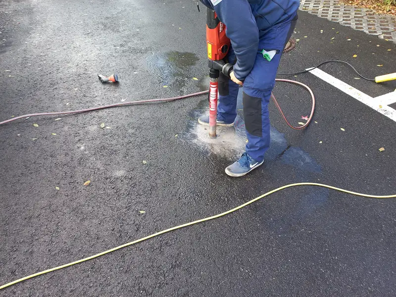 Technicians running a diamond core drill with water feed to drill a clean vertical hole
