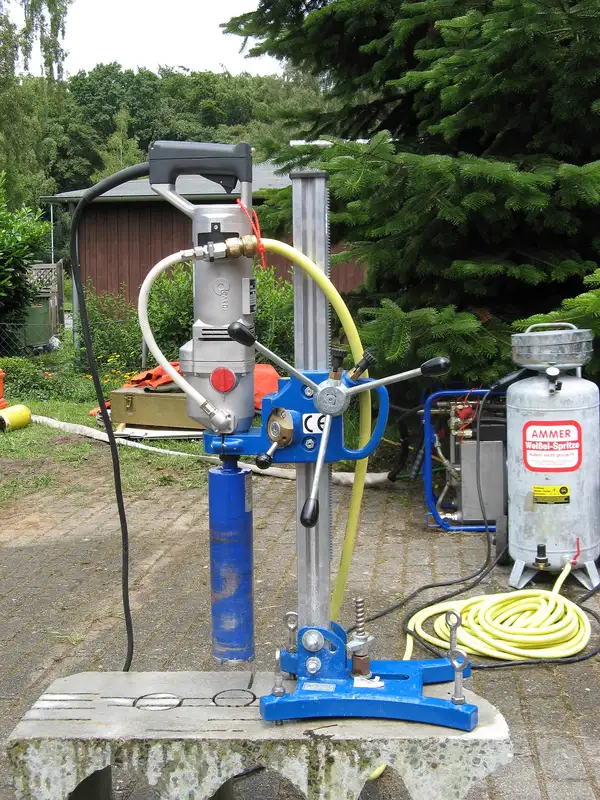 Stand-mounted core drill rig set up for vertical drilling into concrete