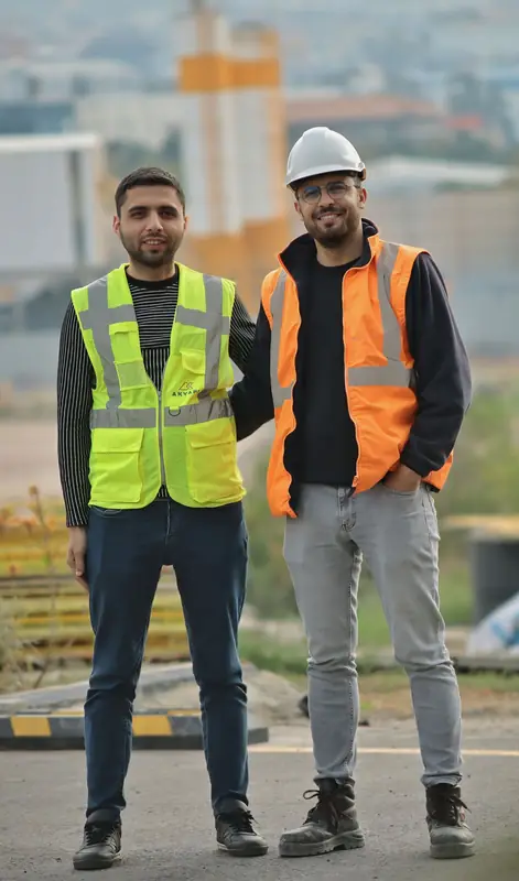 Two construction professionals in hard hats and safety vests on a job site